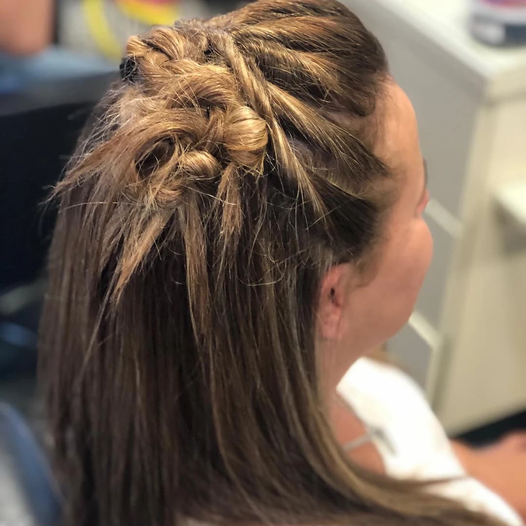 Peinado con trenzas finas y cabello lacio visto de perfil.